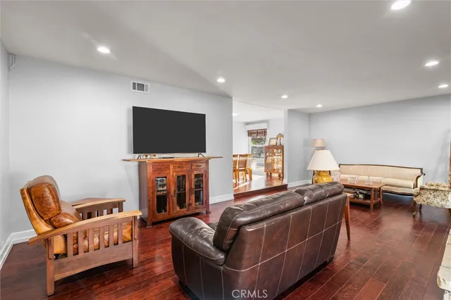 a living room with furniture flat screen tv and wooden floor