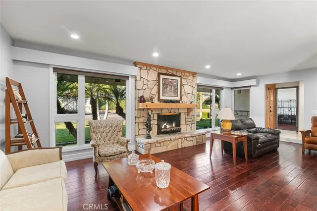 a living room with furniture a fireplace and wooden floor