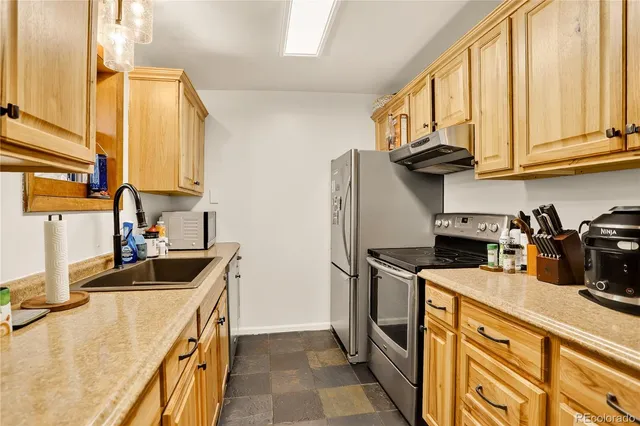 a kitchen with stainless steel appliances granite countertop a sink a stove and cabinets