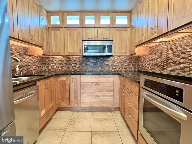 a kitchen with granite countertop stainless steel appliances and cabinets