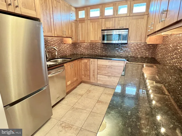 a kitchen with granite countertop a refrigerator and a sink
