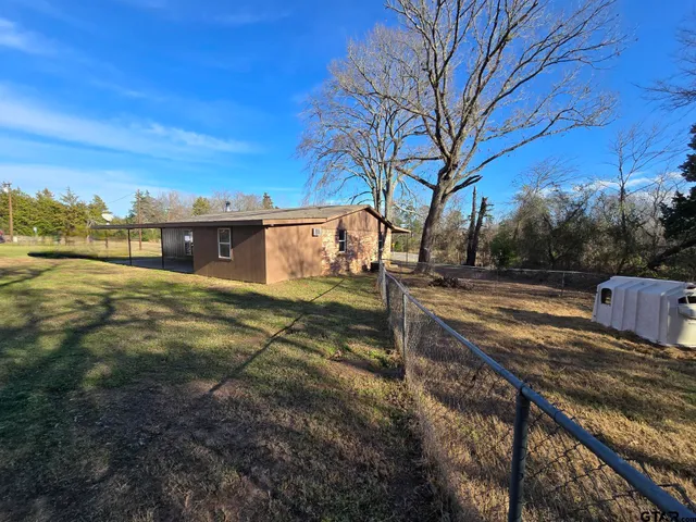 a view of a backyard with wooden fence