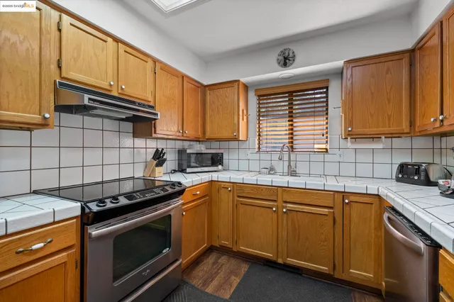 a kitchen with a sink stove top oven and cabinets