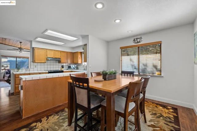 a dining room with stainless steel appliances kitchen island granite countertop a table and chairs
