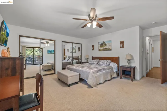 a spacious bedroom with a bed a couch and large window