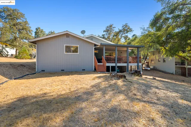 a view of a house with a backyard and tree
