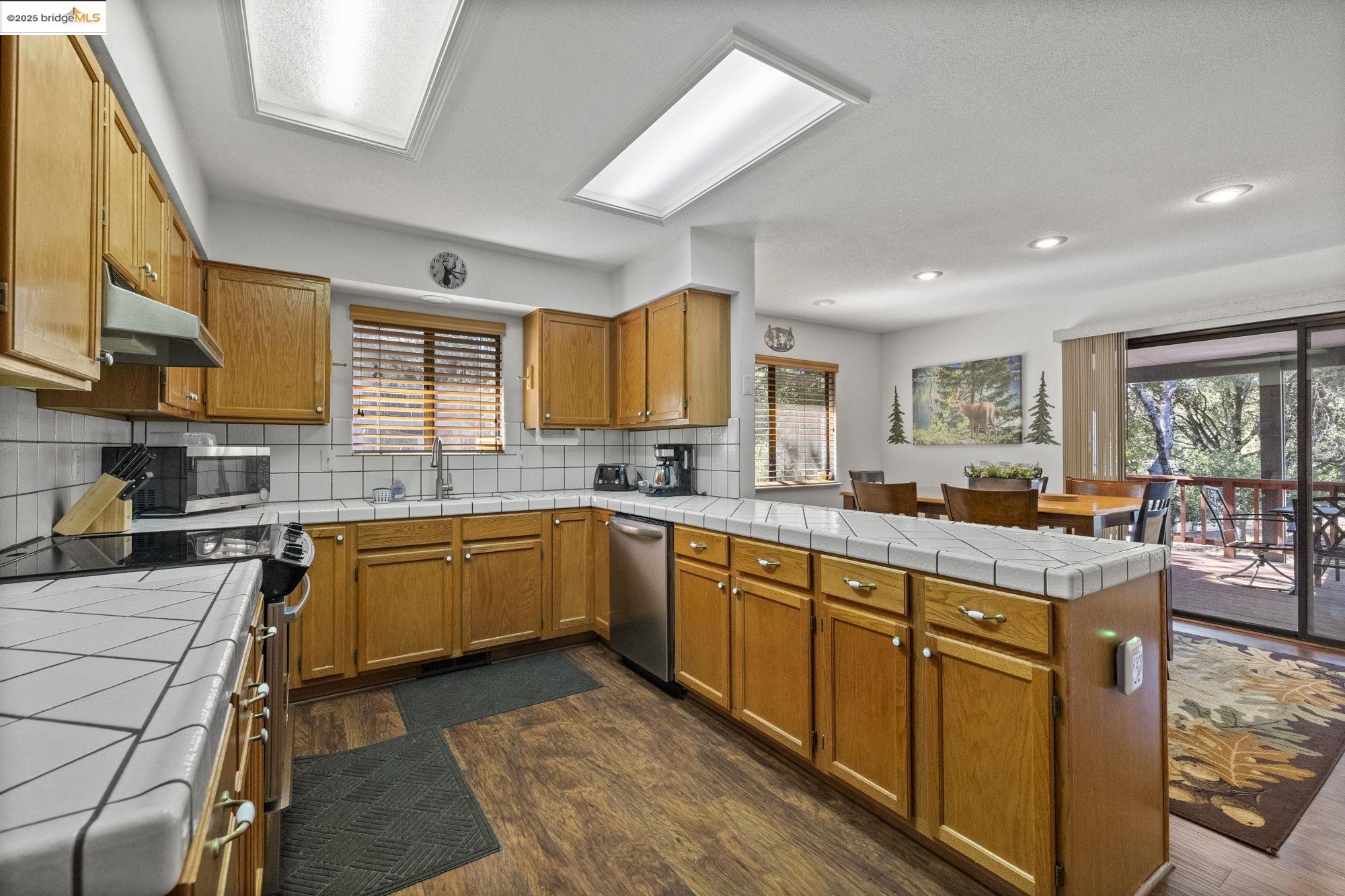20747 Rising Hill Circle Groveland, CA 95321 - Photo 44 of 60 a open kitchen with stainless steel appliances granite countertop a stove top oven a sink dishwasher and cabinets with wooden floor
