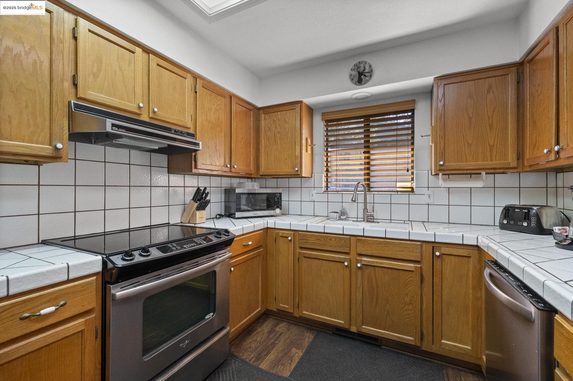 20747 Rising Hill Circle Groveland, CA 95321 - Photo 45 of 60 a kitchen with a sink stove top oven and cabinets