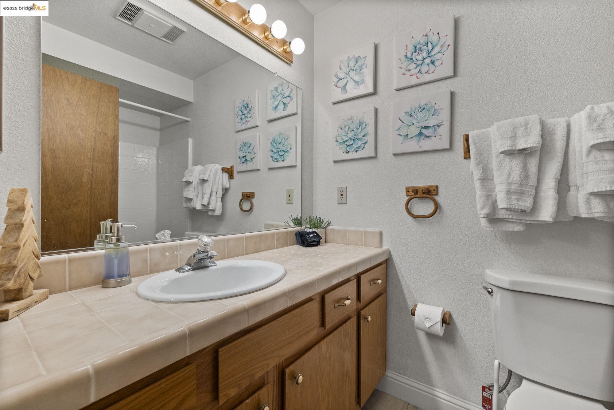 20747 Rising Hill Circle Groveland, CA 95321 - Photo 54 of 60 a bathroom with a granite countertop sink vanity mirror and toilet