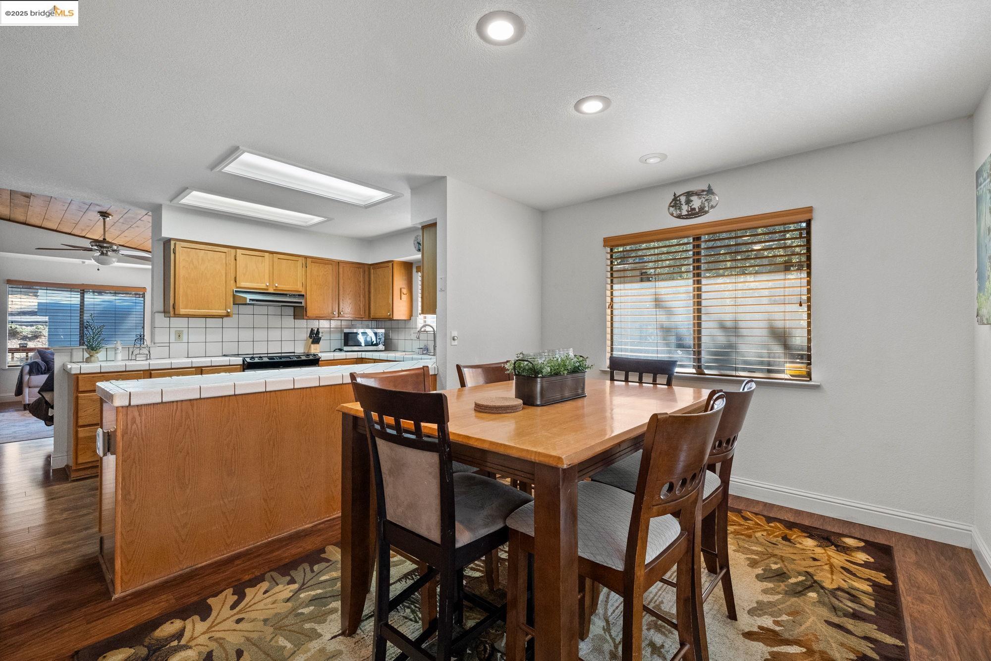 20747 Rising Hill Circle Groveland, CA 95321 - Photo 6 of 60 a dining room with stainless steel appliances kitchen island granite countertop a table and chairs