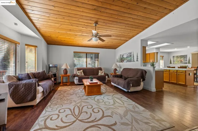 a living room with furniture kitchen view and a large window
