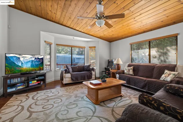 a living room with furniture a flat screen tv and a large window