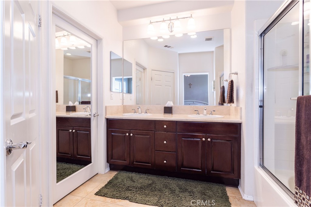 11220 Paseo Sonesta Porter Ranch, CA 91326 - Photo 18 of 46 a bathroom with a vanity a sink a large mirror and shower