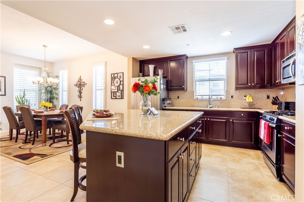 11220 Paseo Sonesta Porter Ranch, CA 91326 - Photo 3 of 46 a kitchen with stainless steel appliances granite countertop a sink a stove and a refrigerator