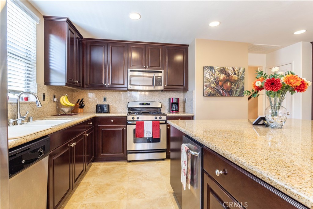 11220 Paseo Sonesta Porter Ranch, CA 91326 - Photo 7 of 46 a kitchen with stainless steel appliances granite countertop a sink stove and refrigerator
