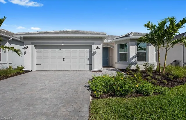 a front view of a house with a yard and garage