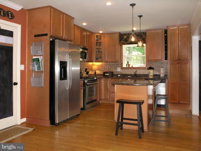 2419 Silver Fox Lane Reston, VA 20191 - Photo 15 of 30 a kitchen with stainless steel appliances granite countertop a refrigerator a stove a sink a dining table and chairs with wooden floor