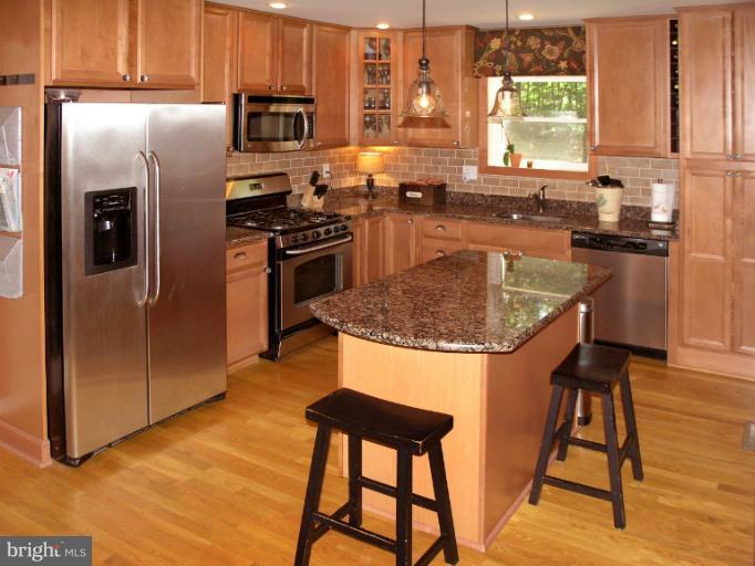 2419 Silver Fox Lane Reston, VA 20191 - Photo 22 of 30 a kitchen with stainless steel appliances granite countertop a stove a refrigerator and a stove top oven