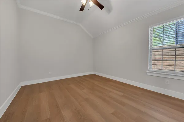 an empty room with a window and wooden floor