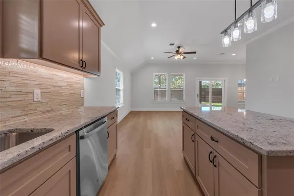 a kitchen with granite countertop stainless steel appliances a sink stove and cabinets
