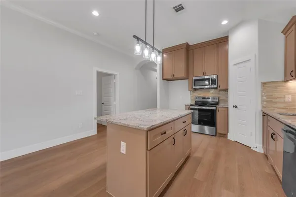 a kitchen with stainless steel appliances granite countertop a refrigerator a stove and a sink