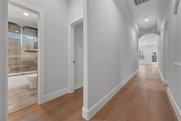 a view of a hallway with wooden floor