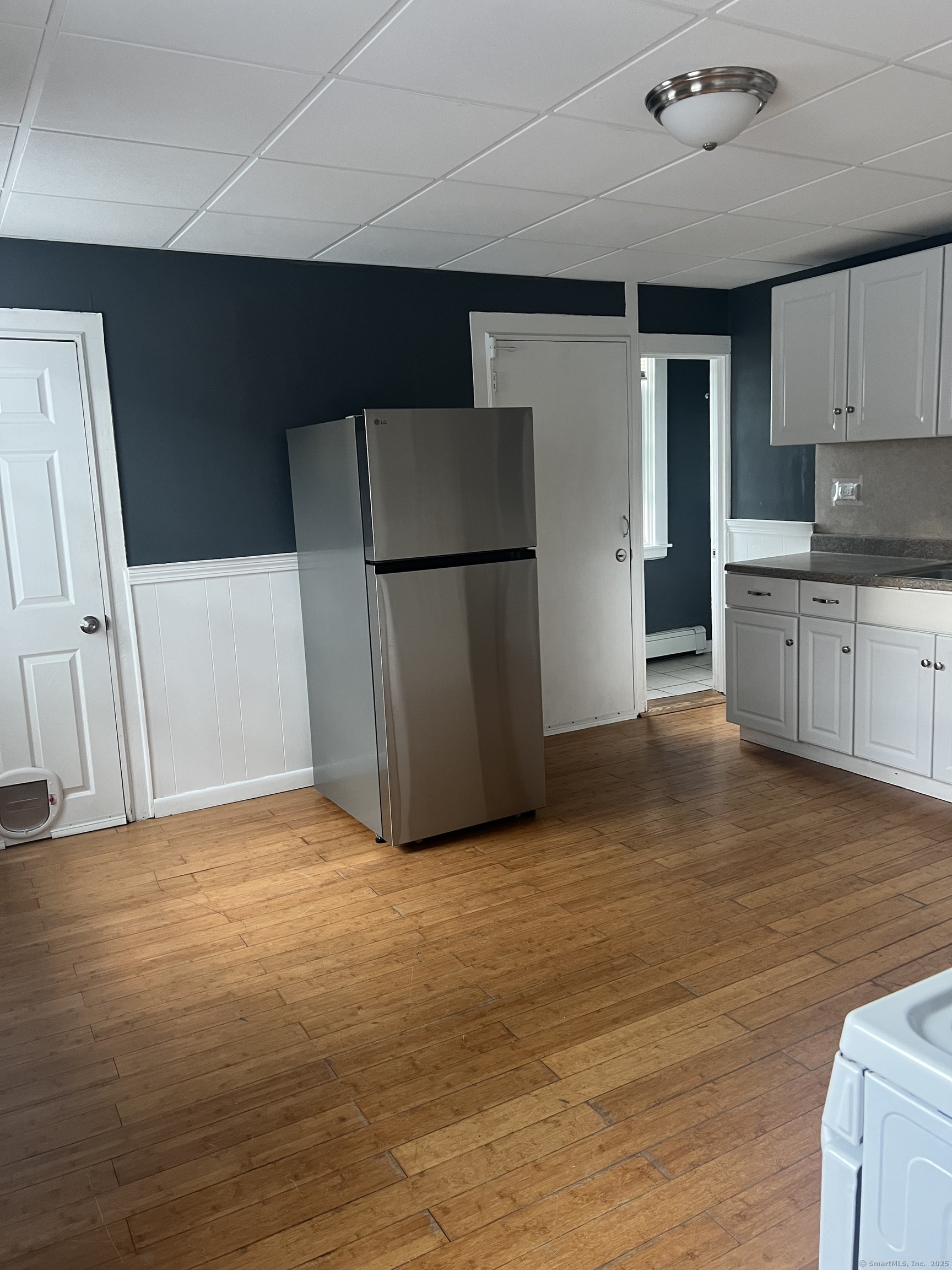 52 Spring Street Middletown, CT 06457 - Photo 5 of 6 a view of kitchen with refrigerator cabinets and wooden floor