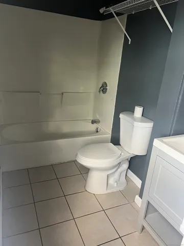 a white toilet sitting next to a bath tub