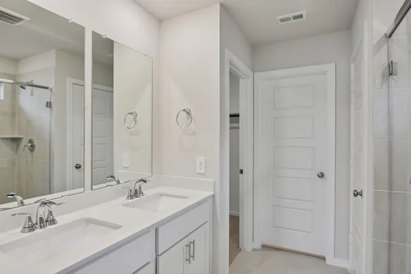 a bathroom with a sink shower and a mirror