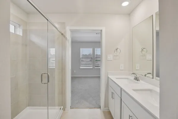 a spacious bathroom with a shower sink and mirror