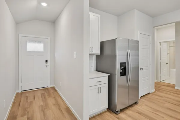 a view of a kitchen with refrigerator and wooden floor