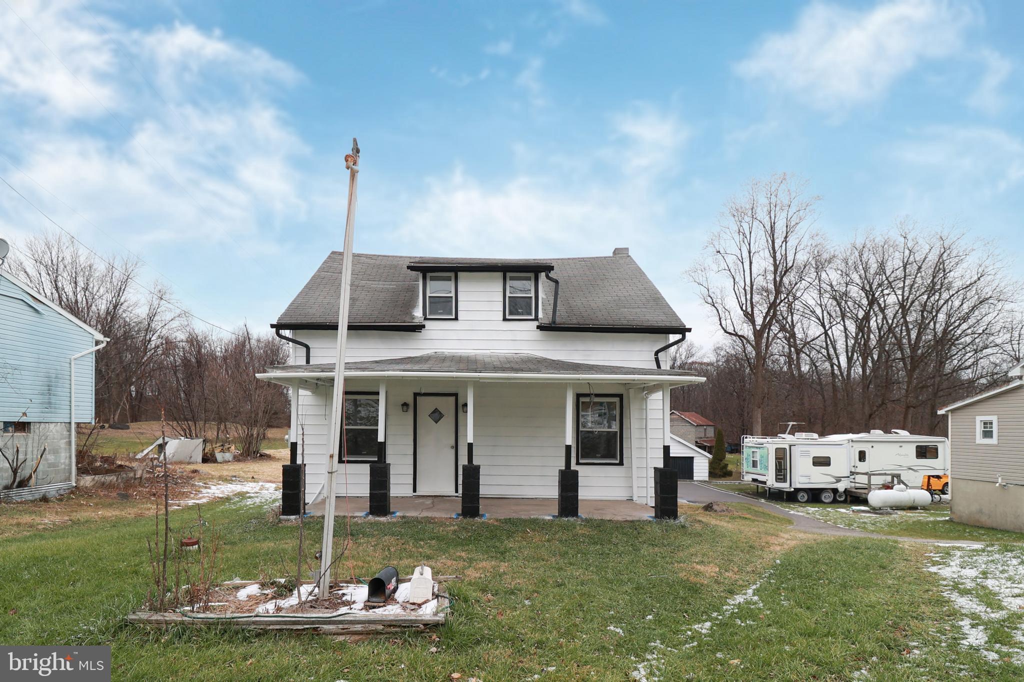 a front view of a house with a garden and trees
