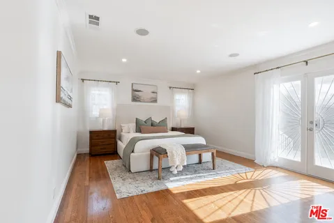 a bedroom with a bed and wooden floor