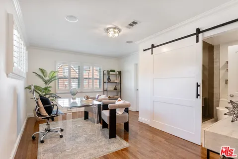 a view of a workspace with furniture and a window