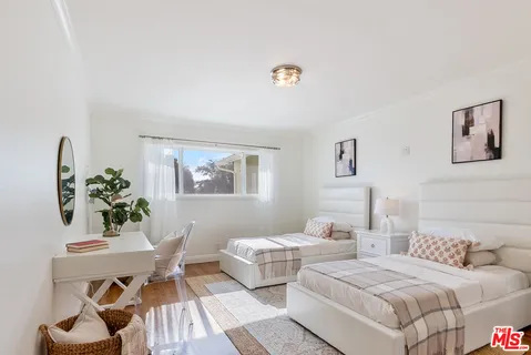 a bedroom with two beds and a table