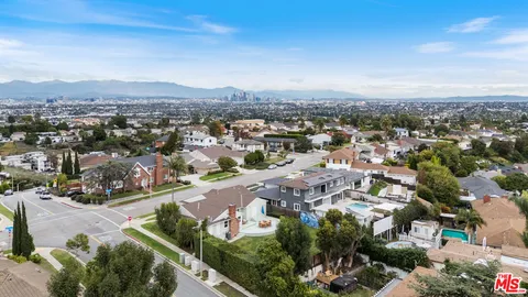 an aerial view of residential houses with outdoor space and trees