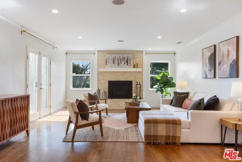a living room with fireplace furniture and a wooden floor