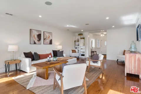 a living room with furniture kitchen view and a table