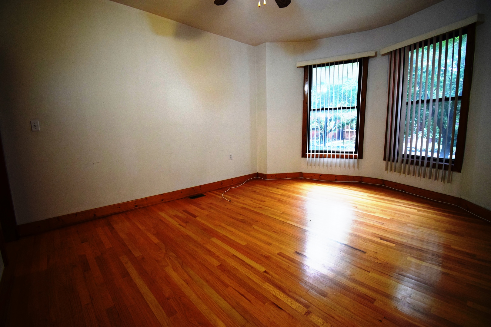 4326 North Kenmore Avenue, Unit 1 Chicago, IL 60613 - Photo 3 of 14 a view of an empty room with wooden floor and a window