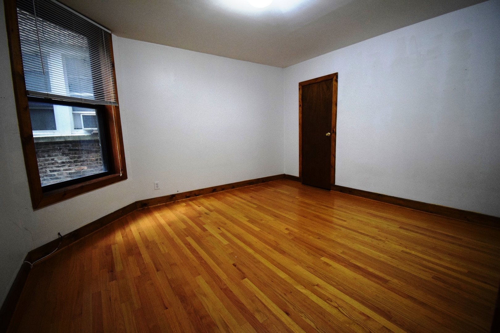 4326 North Kenmore Avenue, Unit 1 Chicago, IL 60613 - Photo 5 of 14 a view of an empty room with wooden floor and a window