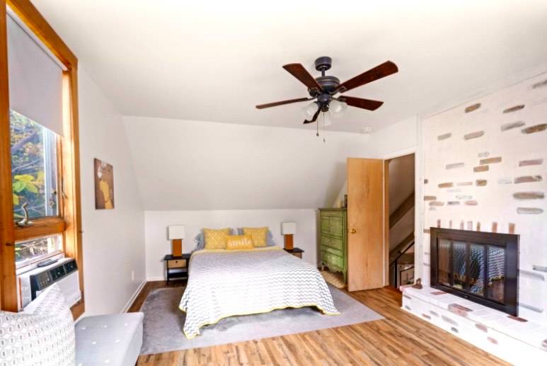 32 Surf Drive Amagansett, NY 11930 - Photo 11 of 14 a bedroom with a bed and a fireplace