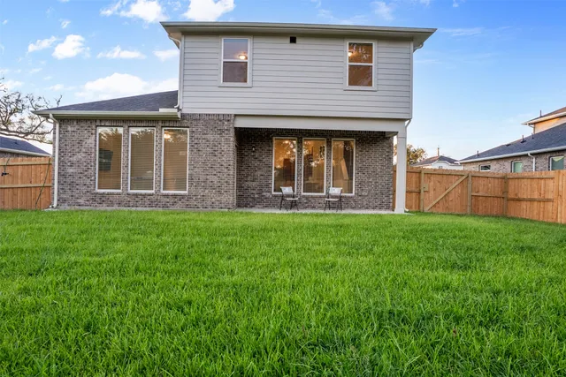 a view of a house with brick walls and a yard with windows