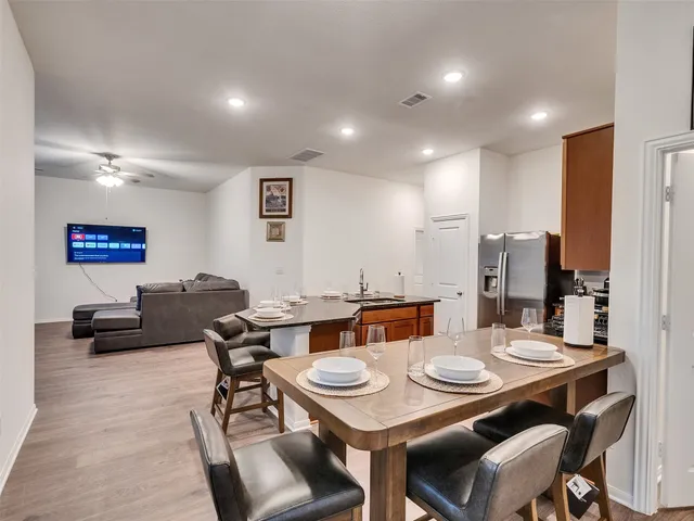 a view of a kitchen with a dining table chairs and a refrigerator