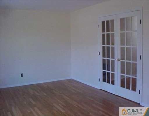 33 Burnham Road East Brunswick, NJ 08816 - Photo 2 of 7 a view of an empty room with wooden floor and a window