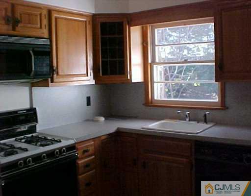 33 Burnham Road East Brunswick, NJ 08816 - Photo 4 of 7 a kitchen with granite countertop a stove a sink and a microwave
