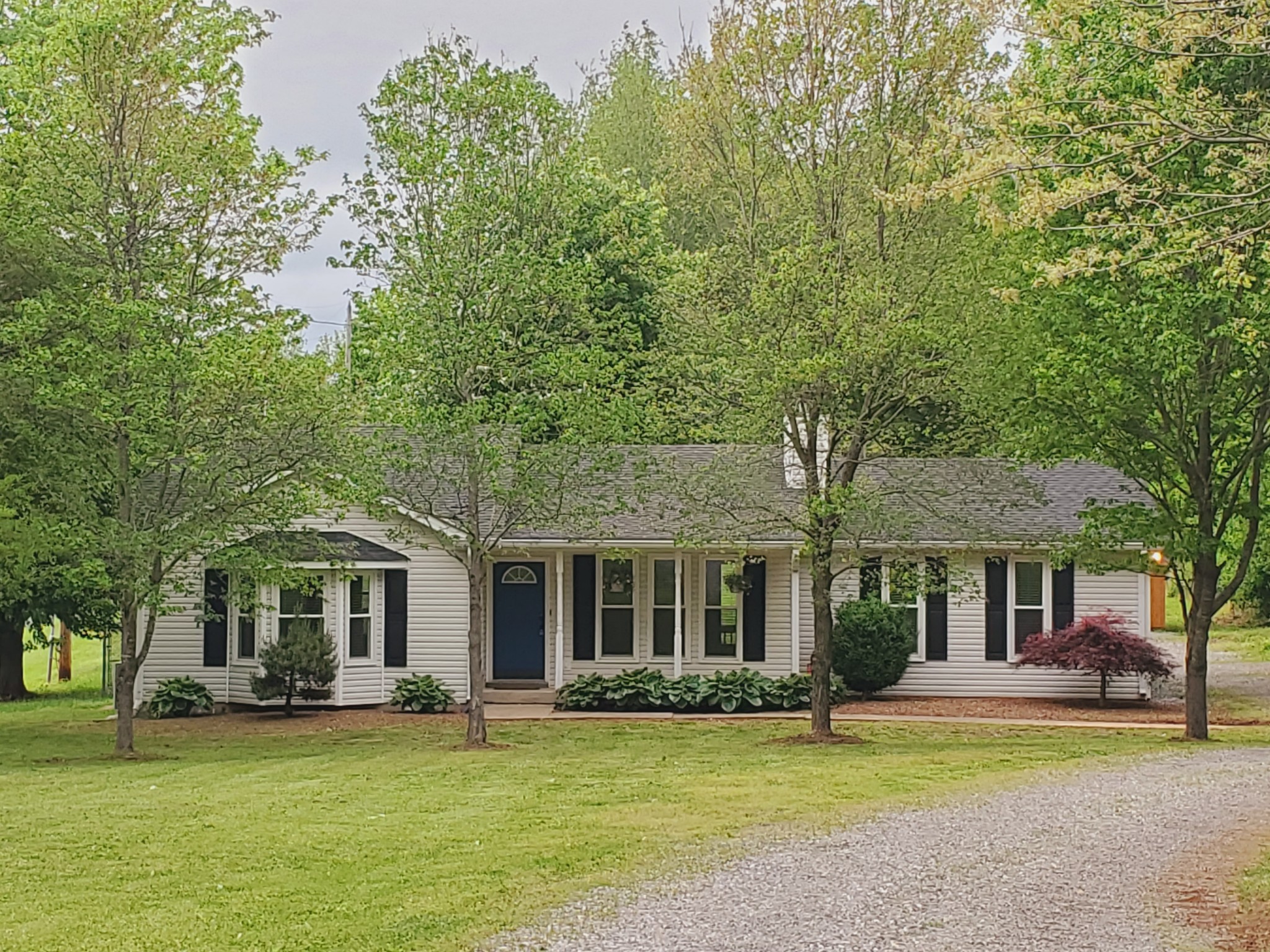 324 West Harper Road Portland, TN 37148 - Photo 1 of 25 a front view of a house with a garden and trees