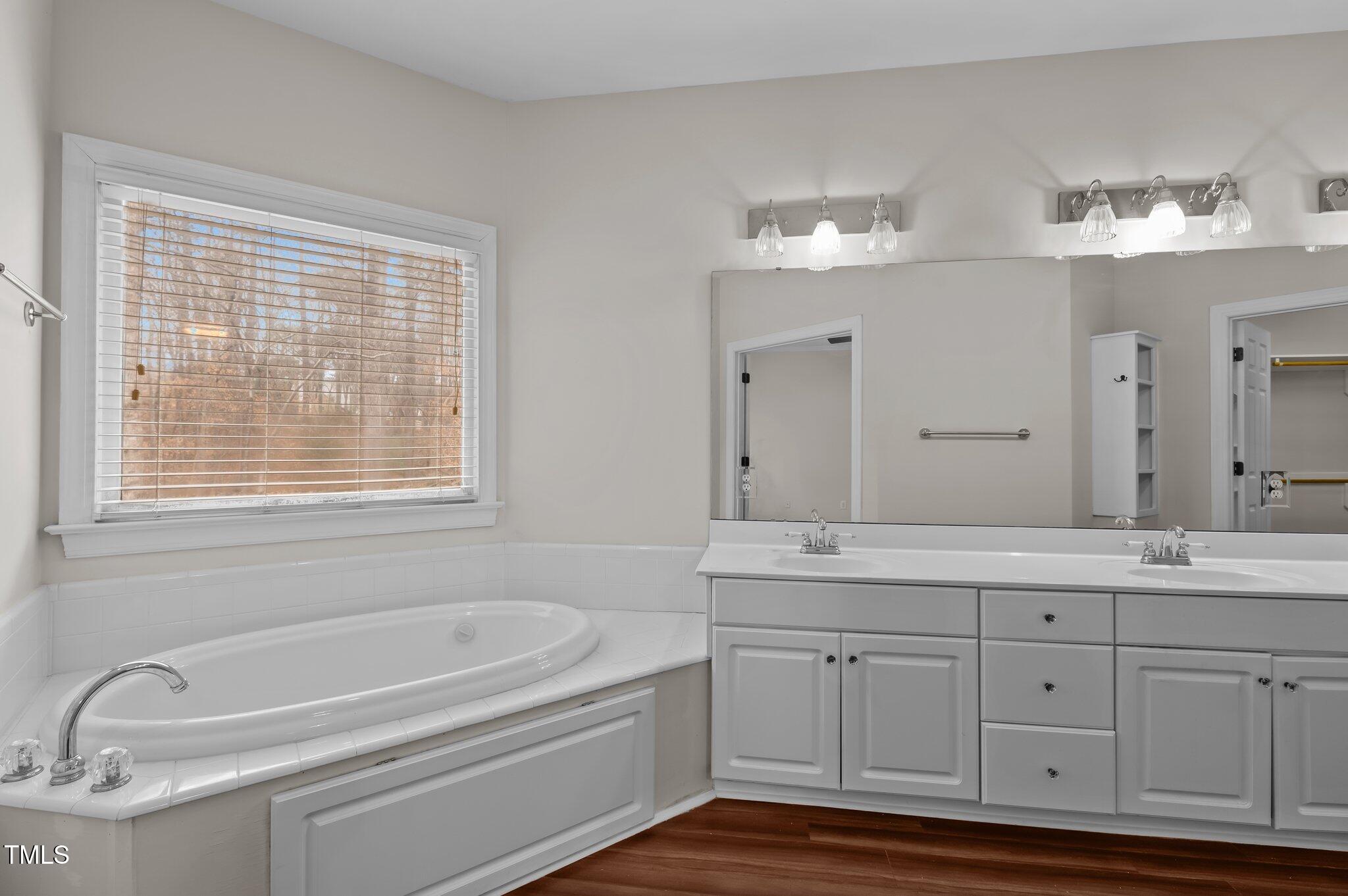 2517 Mt Vernon Church Road Raleigh, NC 27614 - Photo 24 of 45 a bathroom with a tub a double vanity sink and a window
