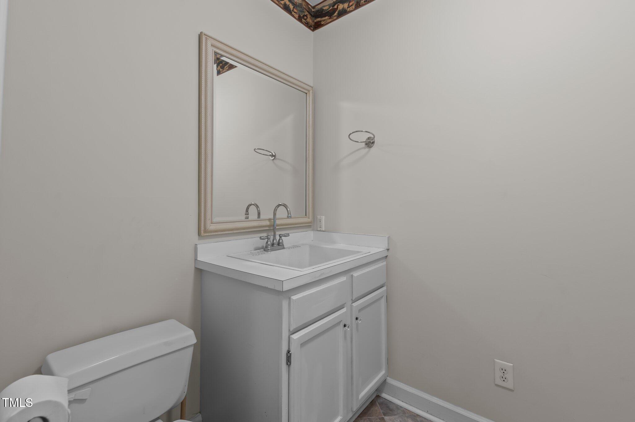 2517 Mt Vernon Church Road Raleigh, NC 27614 - Photo 34 of 45 a bathroom with a toilet a sink and mirror