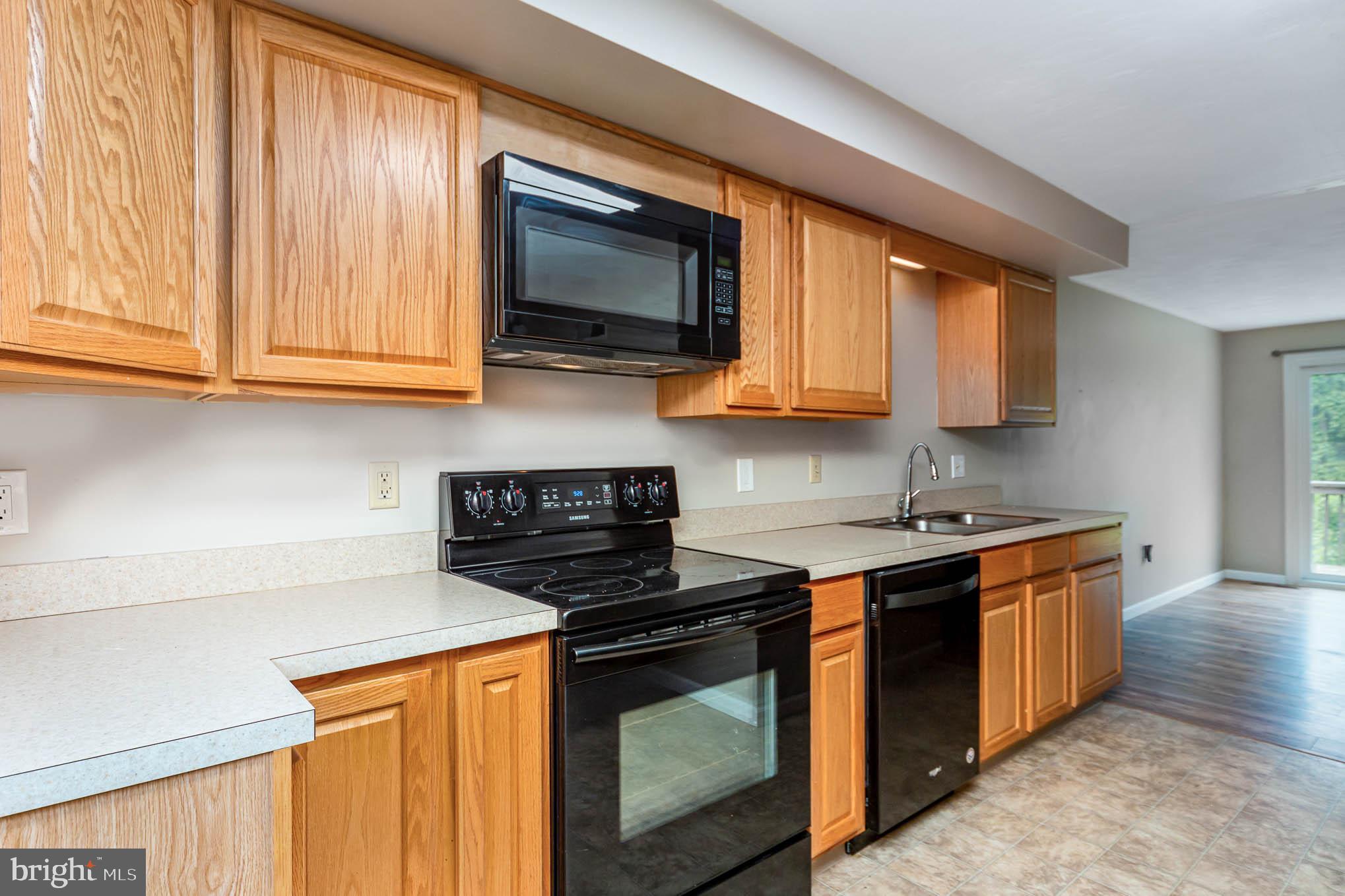 568 Valley Road Enola, PA 17025 - Photo 7 of 27 a kitchen with stainless steel appliances wooden cabinets and a stove top oven