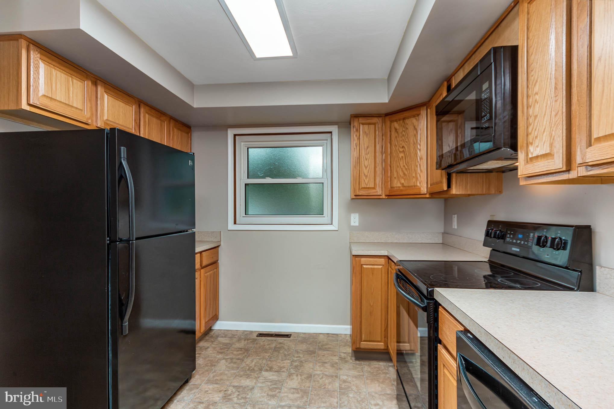 568 Valley Road Enola, PA 17025 - Photo 8 of 27 a kitchen with stainless steel appliances granite countertop a refrigerator a stove and a sink with cabinets